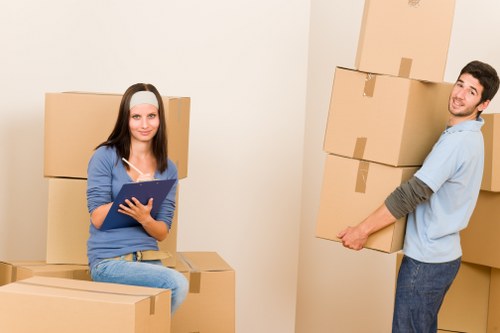 Movers carrying furniture through a Manor House property